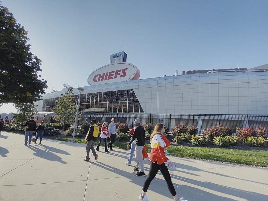 Fans walking in front of the exterior of Arrowhead Stadium with the CHIEFS sign