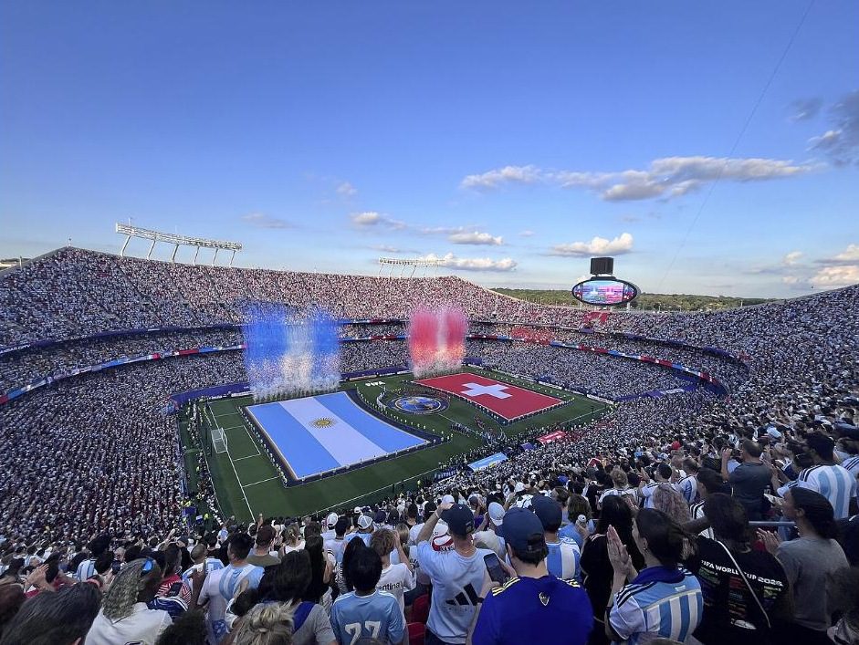 Arrowhead Stadium before the World Cup quarterfinal between Argentina and Switzerland, with giant flags unrolled on the field and the stands full