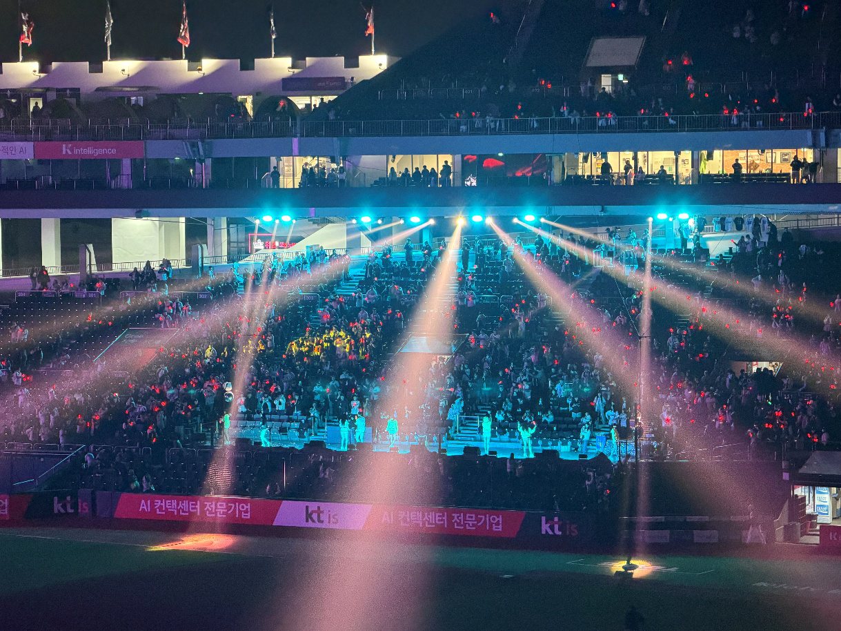 Fans in the cheering section enjoying Mirror Ball Time as lights sweep through the dark ballpark